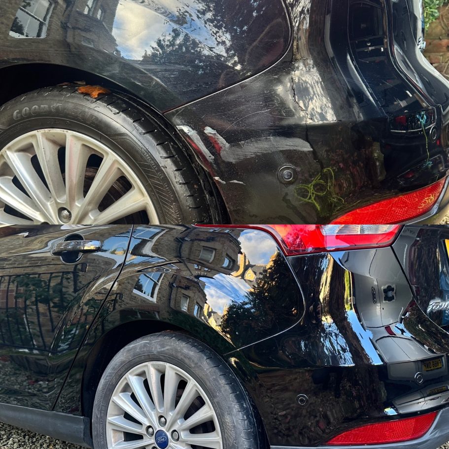 Close-up of two black cars showing different damage levels on the rear sections.